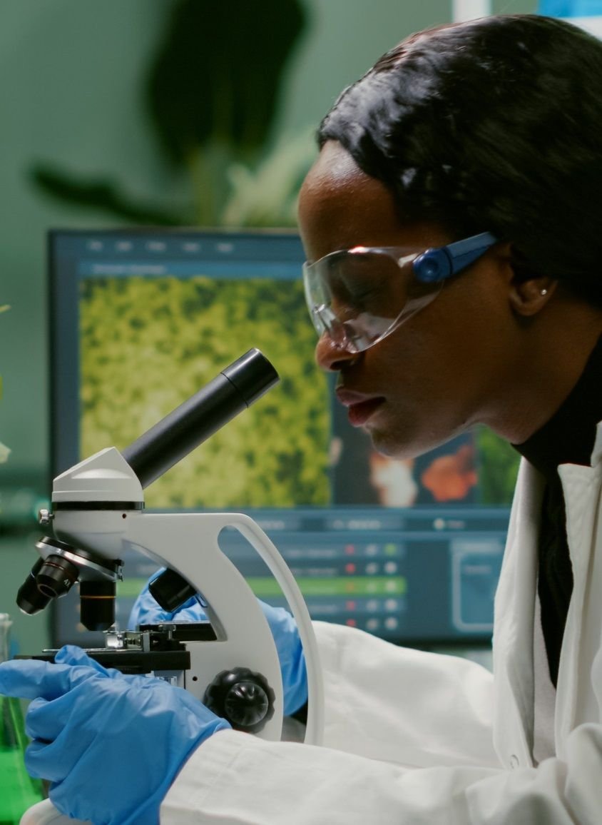 A scientist examines a sample under a microscope in a laboratory
