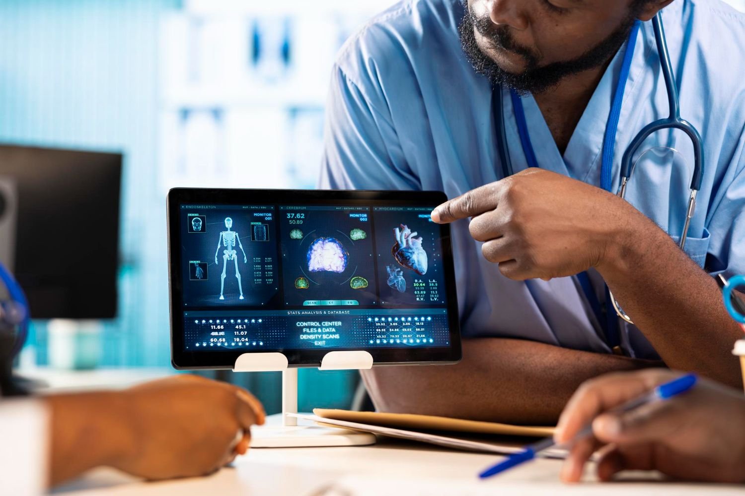 A clinician explains information on a tablet displaying medical imaging