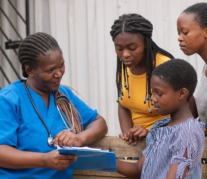 A community health worker reviews information with a family outdoors