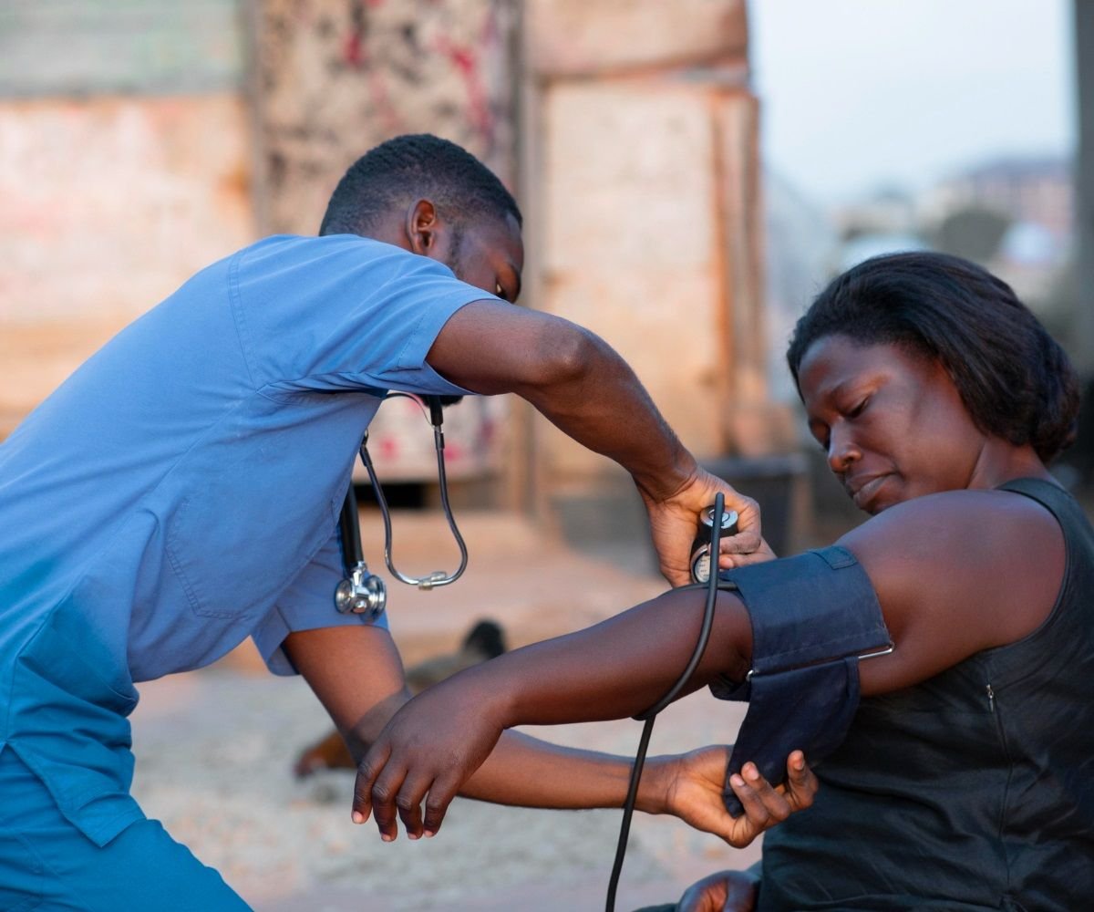 A clinician measures a patient&rsquo;s blood pressure outdoors